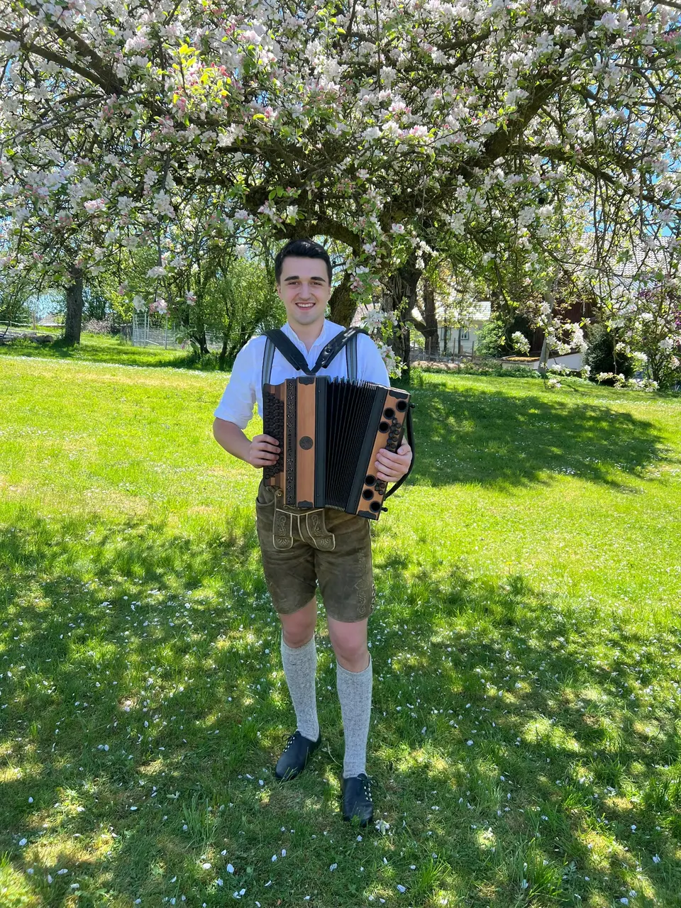 Severin Müller mit seiner Ziach im blühenden Obstgarten